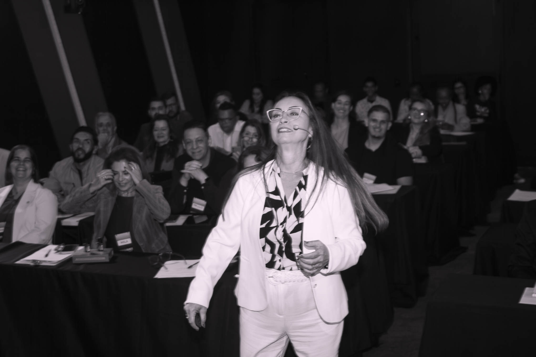 Eunice Reis andando pelo palco com microfone de lapela durante a Imersão Fullness